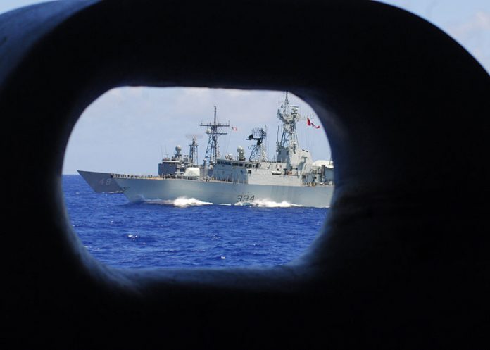 La frégate canadienne HMCS Regina (FFH 334) (Image : Wikimedia Commons - PACIFIC OCEAN (June 23, 2008) The Canadian Navy frigate HMCS Regina (FFH 334), front, and the frigate USS Vandegrift (FFG 48) sail on the starboard side of the aircraft carrier USS Kitty Hawk (CV 63). Kitty Hawk is returning to the United States for decommissioning after 47 years of service, 10 of which have been in Japan and will be replaced by the aircraft carrier USS George Washington (CVN 73) this summer. U.S. Navy photo by Mass Communication Specialist 3rd Class Bryan Reckard (Released))