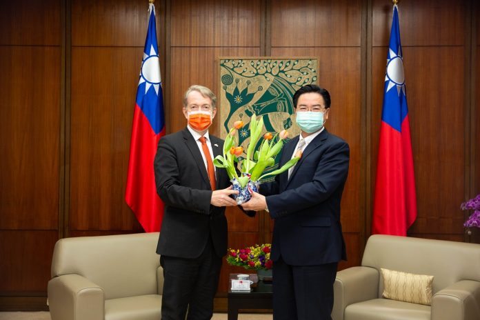 Guy Wittich offrant les tulipes oranges au ministre des Affaires étrangères Joseph Wu pour le jour du Roi (photo facebook NTIO Taiwan)