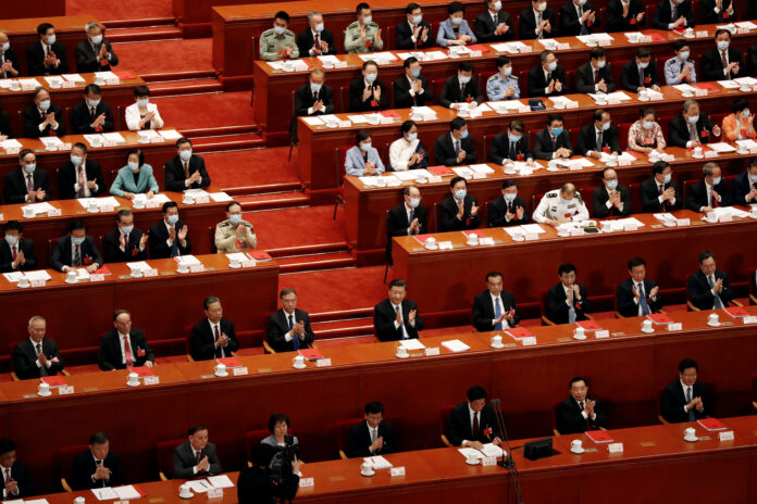Xi Jinping et autres responsables chinois applaudissent le vote de la sécurité nationale de Hong Kong lors de l’Assemblée nationale populaire (Photo REUTERS/Carlos Garcia Rawlins)