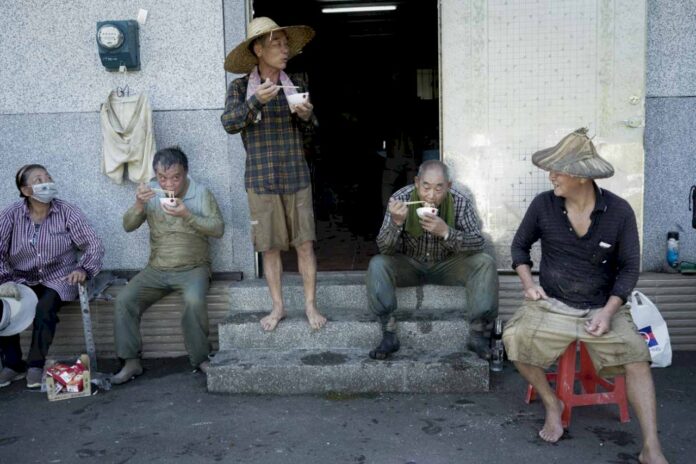Un travail qui commence à 5 h du matin, les fermiers ont déjà faim à 10h. Le fermier Chien Chiu-yang, l’hôte du jour invite tout le monde à manger et à se reposer. (Photo : Chang Liang-i (張良一))